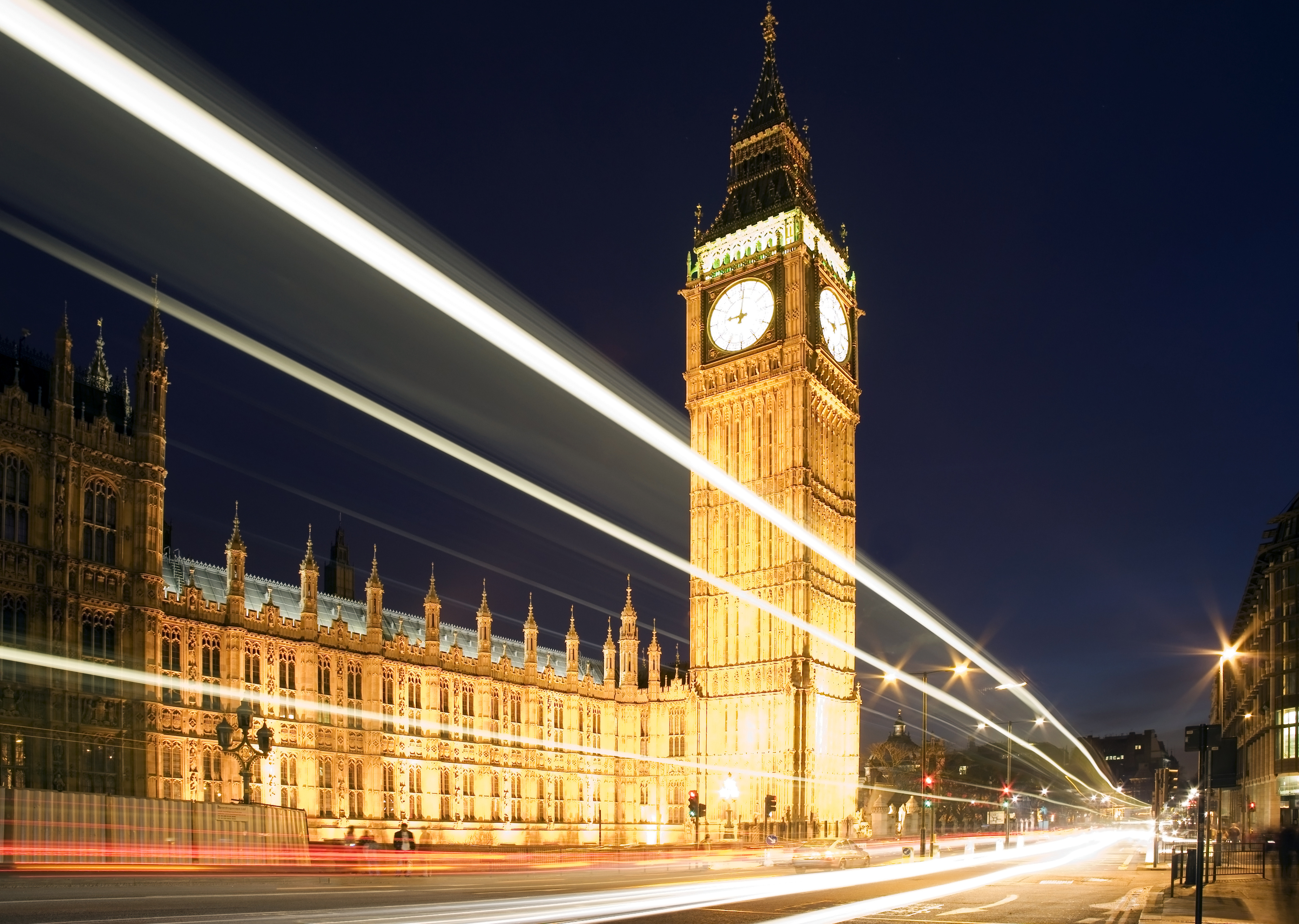 Big Ben in London at night against blue sky. London traffic