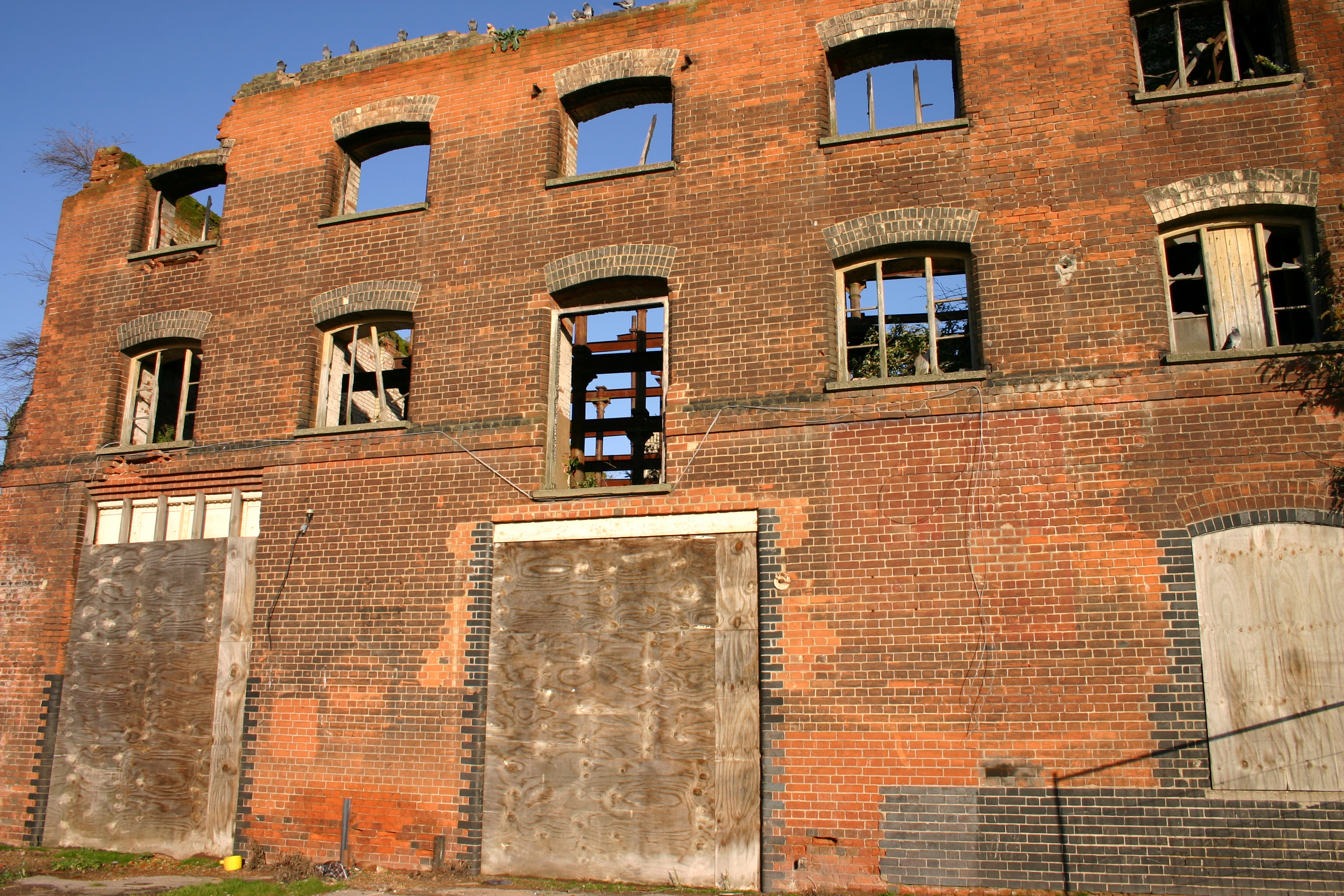 a derelict ruined building with pigeons perched on