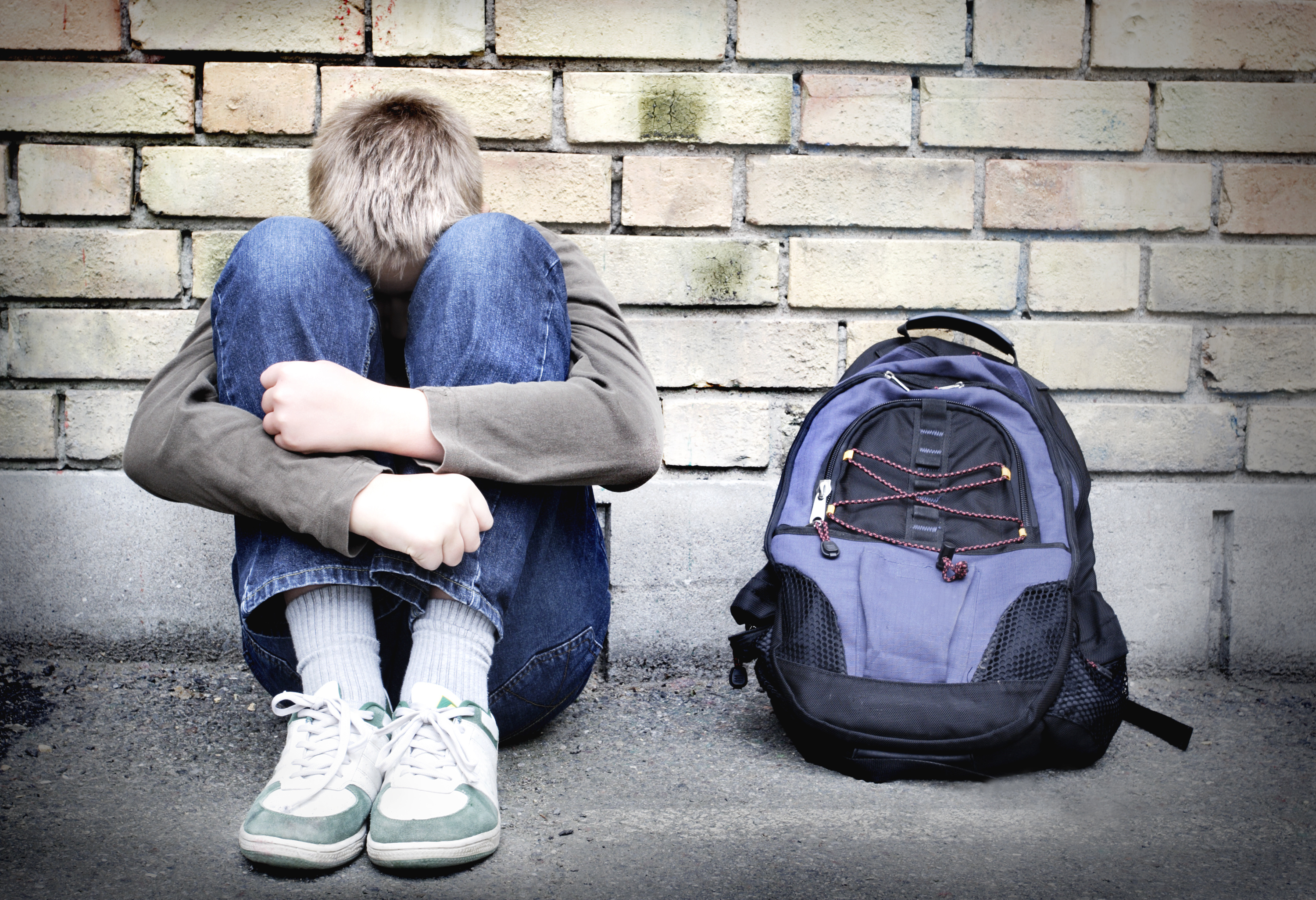 upset boy against a wall