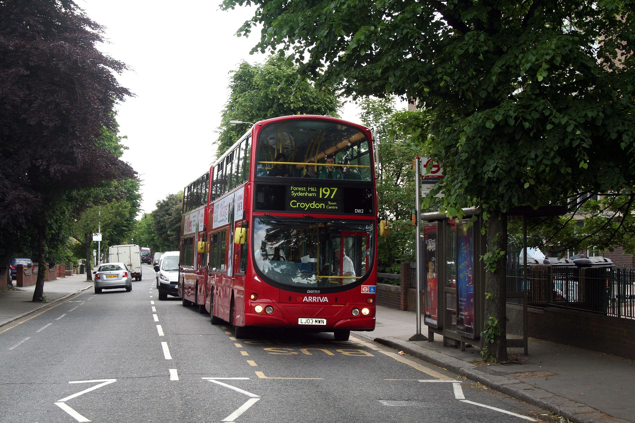 A red bus displaying its destination is Croydon