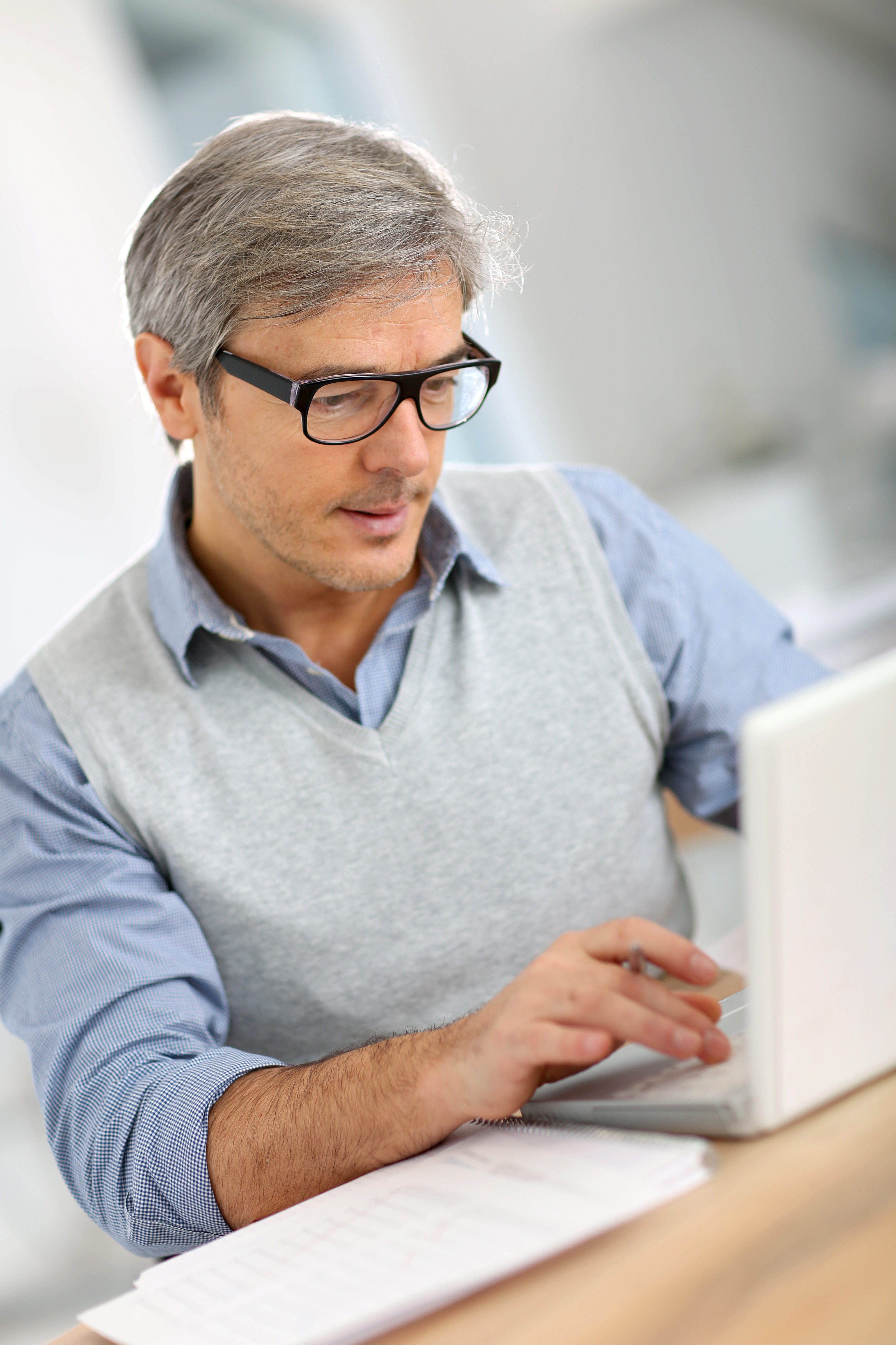 Senior businessman in office working on laptop